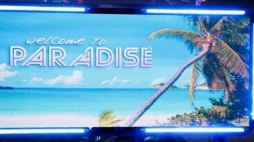 A holographic billboard with a picture of a beach and a palm tree that says 